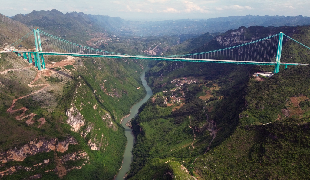 Eine weitere Ansicht der Huajiang-Schlucht-Brücke. Der Boom im chinesischen Straßen- und Brückenbau begann 1989 mit der Einleitung des Nationalen Fernstraßennetzes, einem Netz aus fünf Nord-Süd- und sieben Ost-West-Autobahnen mit einer Gesamtlänge von 37.000 Kilometern. Bild: CC/Glabb