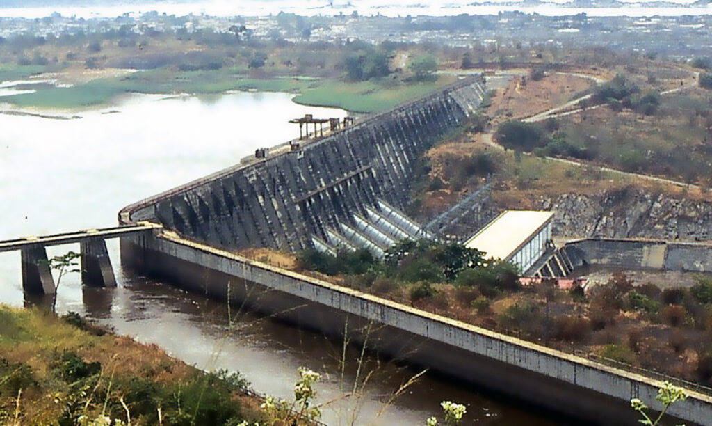 Der Staudamm Inga I, mit dem Zuflußkanal für Inga II im Vordergrund. Der Zugang zu reichlicher, günstiger Energie ist immer der erste Schritt zu einer groß angelegten wirtschaftlichen Entwicklung. Bild: Wikipedia/Alaindg