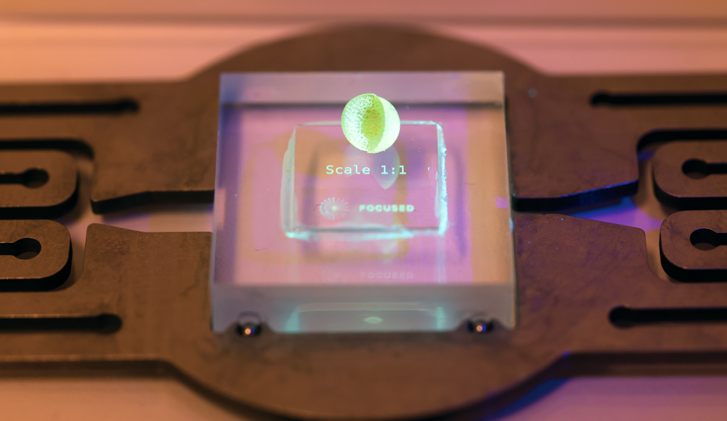 3D gedrucktes Fusionstarget (3-4mm Durchmesser) in 1:1-Skalierung mit Schaum für den Deuterium-Tritium Treibstoff in der Mitte. Im Bild ist ein ungefülltes Target zu sehen. Der Treibstoff würde in den Schaum im Target gefüllt werden, wenn es sich um ein gefülltes Target handeln würde. Bild: Focused Energy